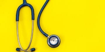 a stethoscope hangs over a yellow background