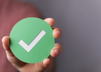 hand holding green checkmark symbol