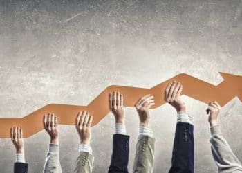 Group of business people holding growing graph in raised hands