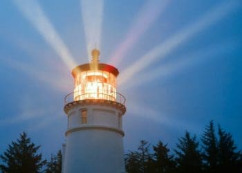 lighthouse shining brightly against dark sky