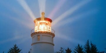 lighthouse shining brightly against dark sky