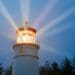 lighthouse shining brightly against dark sky