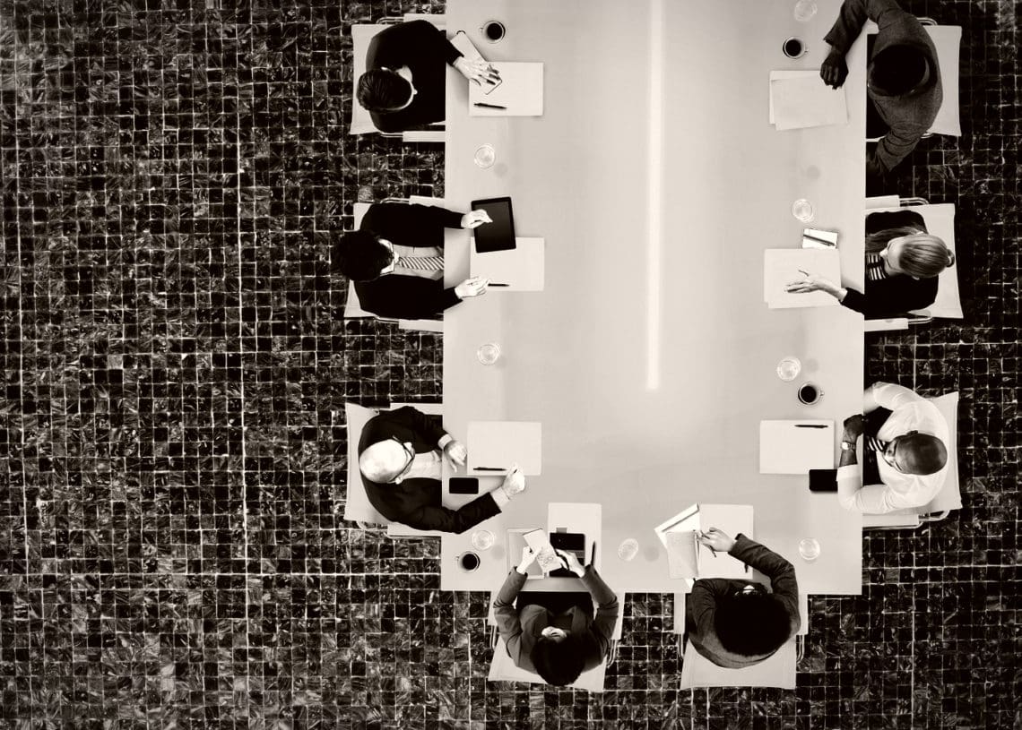 birdseye view of a corporate board meeting around a conference table.
