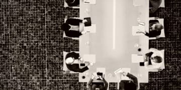 birdseye view of a corporate board meeting around a conference table.