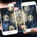 two hands holding smartphones, cryptocurrency payment