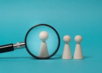 concept of investigation, research, focus on a subject. Wooden figures on blue background