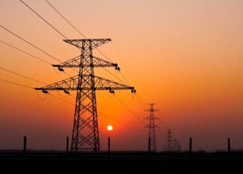 high-voltage power lines with sunset in the background