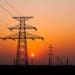 high-voltage power lines with sunset in the background