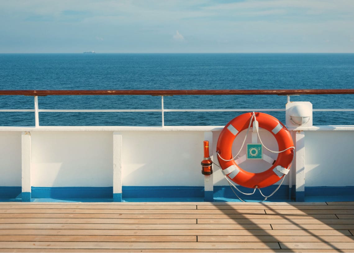 A life buoy sits on a ship gunnel, above board