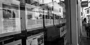 real estate listings sit in a store front window.