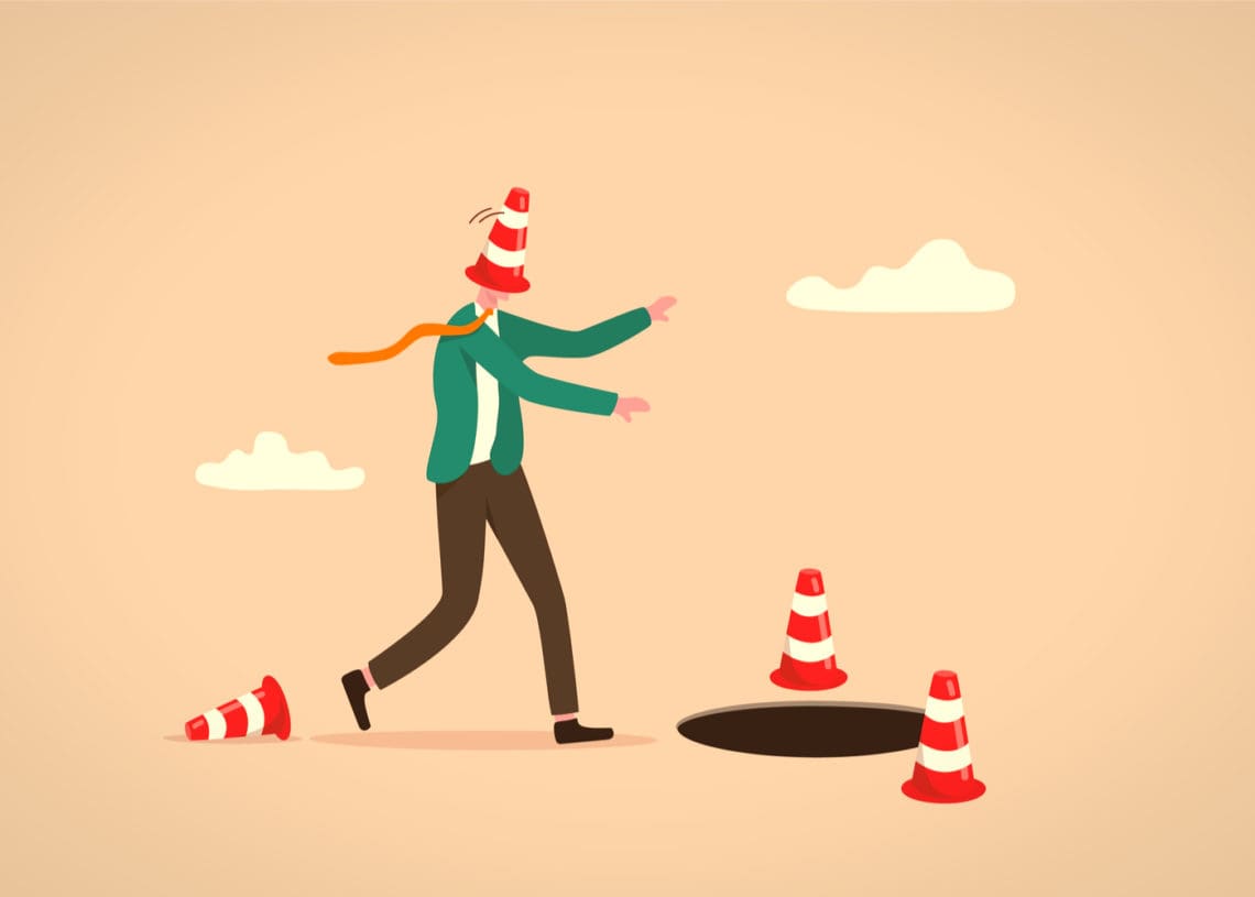 Illustration of a man with a cone on his head stumbling toward a manhole.