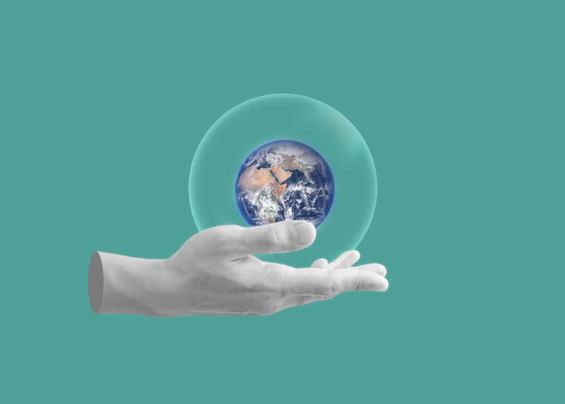 Abstract image including a globe, a hand, and earth