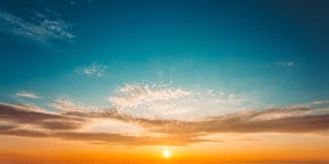 The sun is setting over fields.