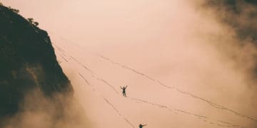 Two tightropers walk above the clouds