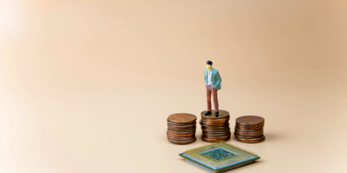 Figure stands on pennies looking down at semiconductor