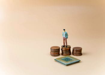 Figure stands on pennies looking down at semiconductor