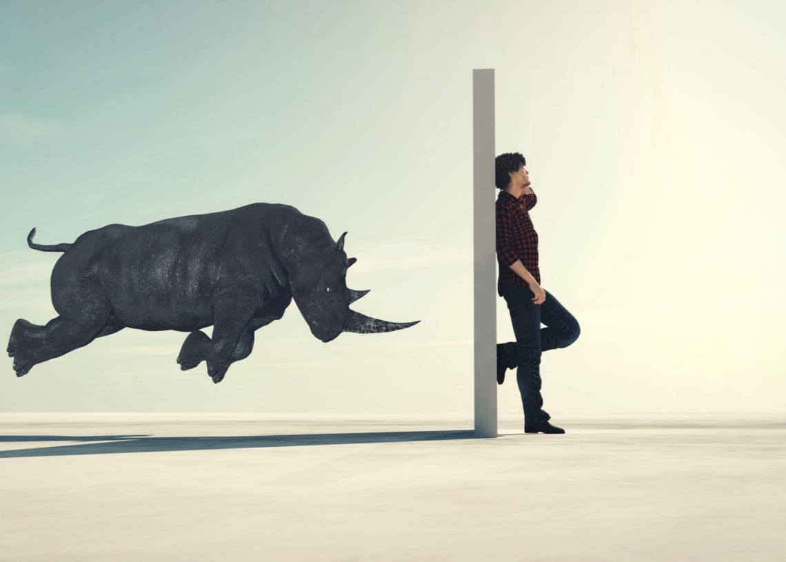 3d render of a rhino charging a closed door before which a man stands on a call