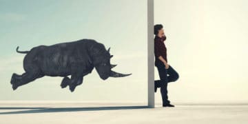 3d render of a rhino charging a closed door before which a man stands on a call
