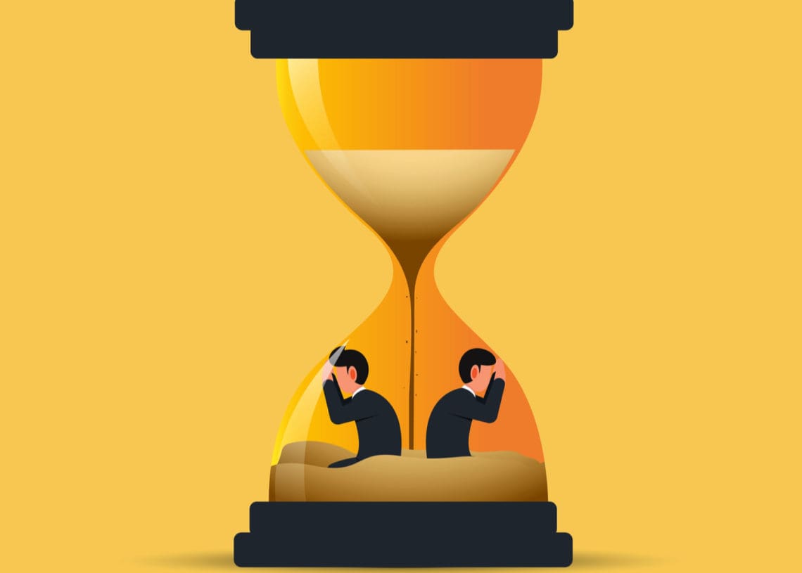 two business men stuck inside emptying hourglass