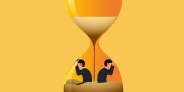 two business men stuck inside emptying hourglass