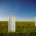 numerous doors stand in a field