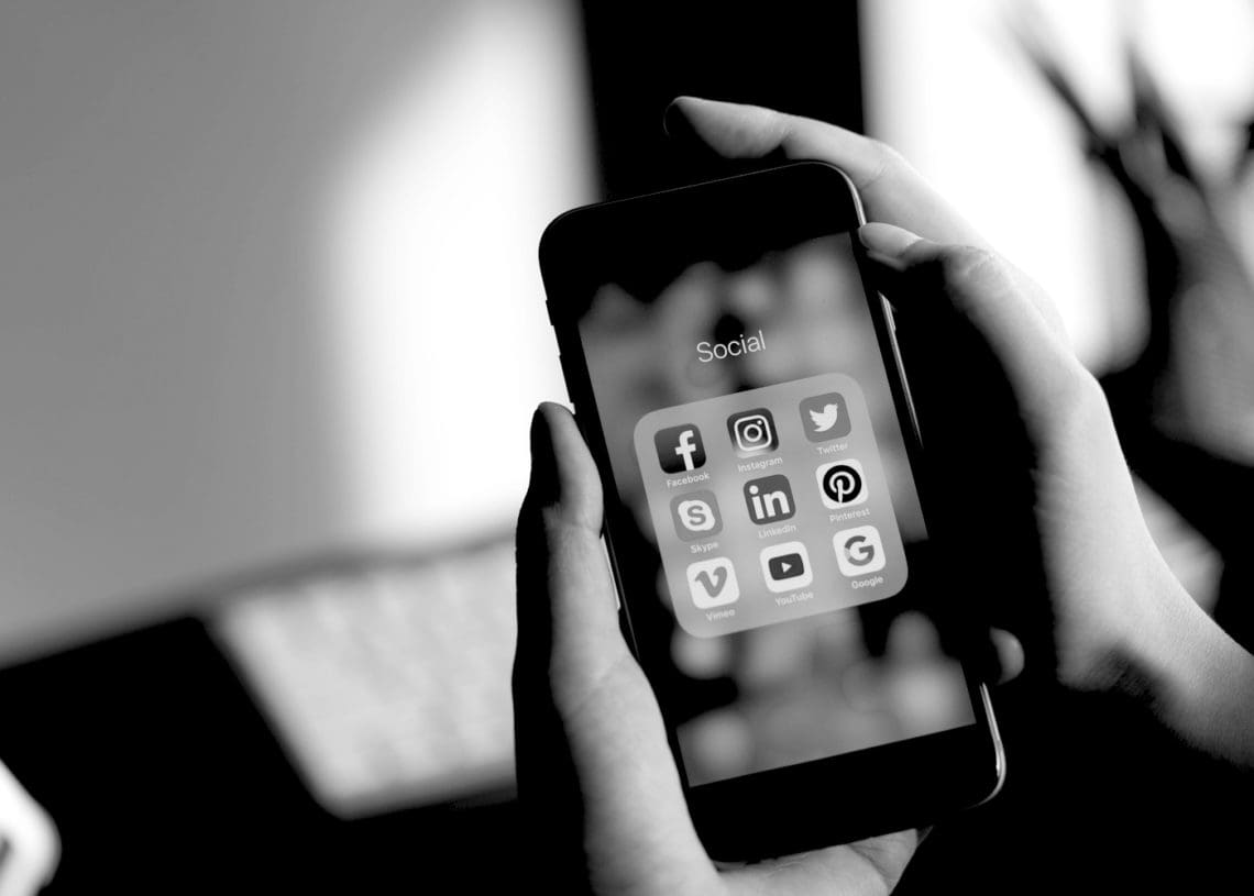 b and w a person uses a smart phone with social media
