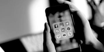 b and w a person uses a smart phone with social media