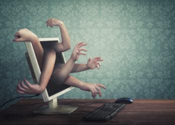 Arms extended from computer screen to signify hackers