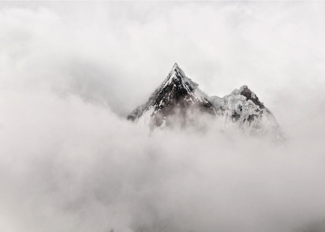 a mountain peaks out of the mist
