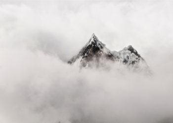 a mountain peaks out of the mist