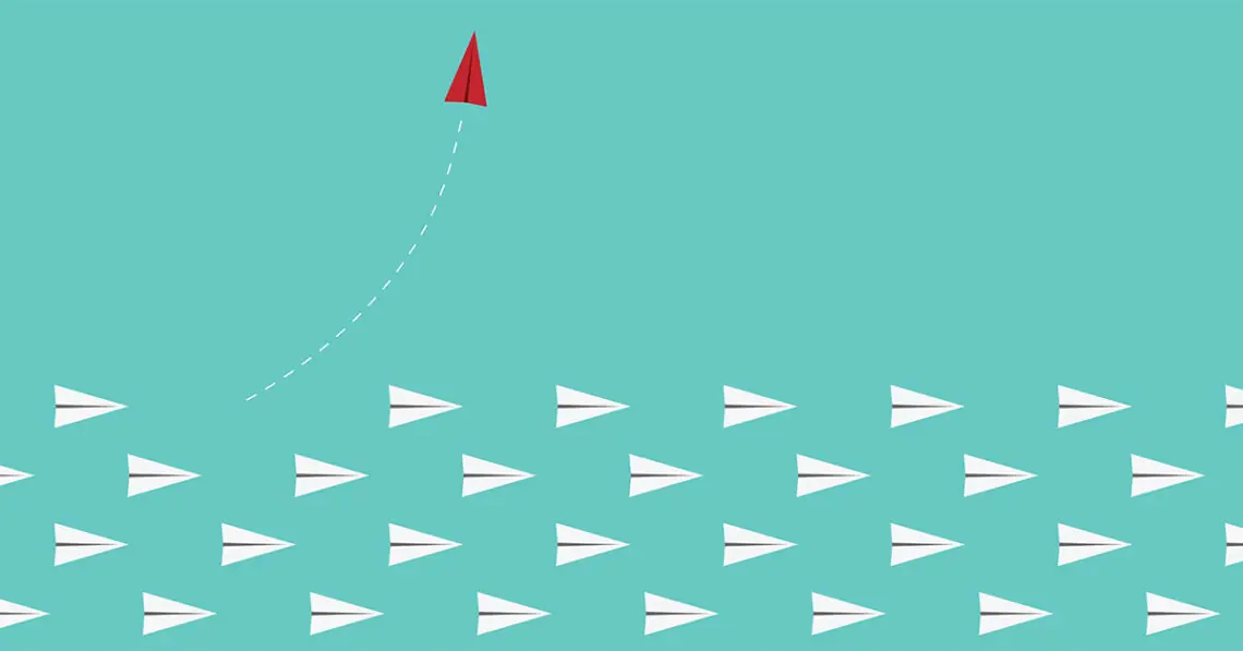red paper airplane leaves other paper airplanes
