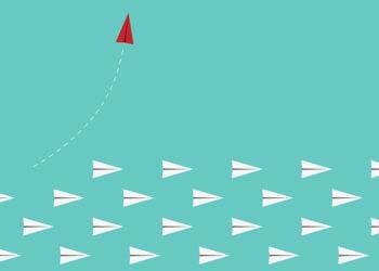 red paper airplane leaves other paper airplanes