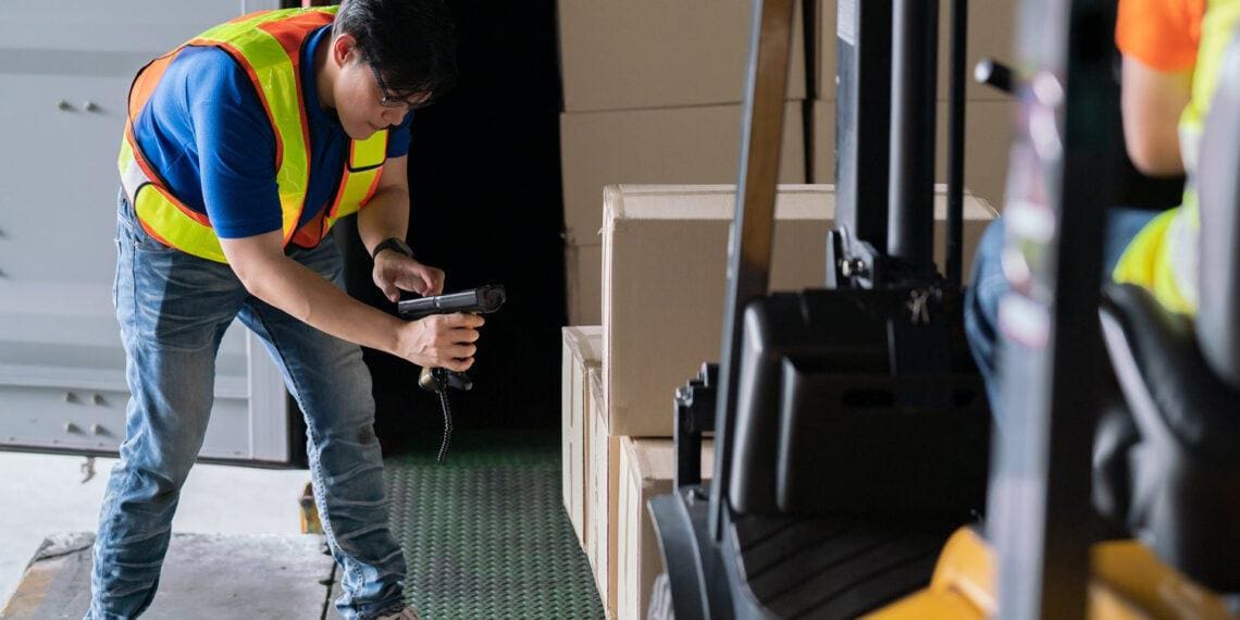 man scanning boxes on forklift