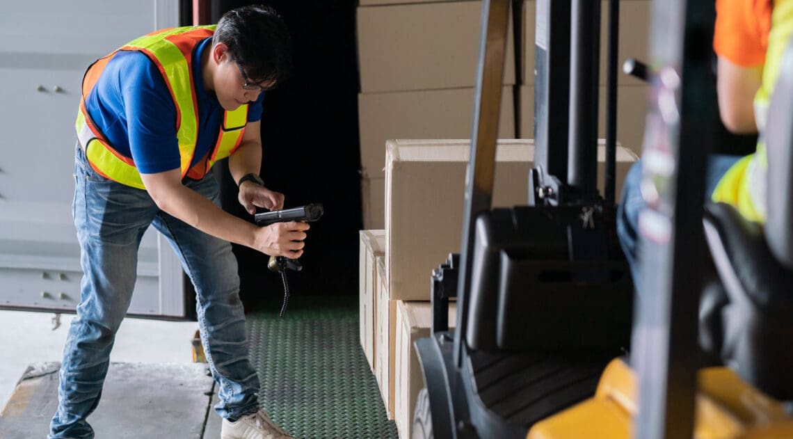 man scanning boxes on forklift