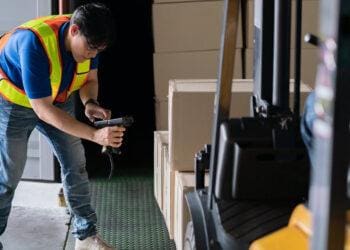 man scanning boxes on forklift