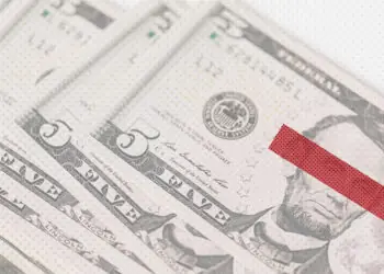 Stack of dollar bills with eyes covered up