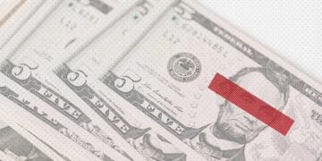 Stack of dollar bills with eyes covered up