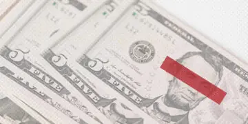 Stack of dollar bills with eyes covered up