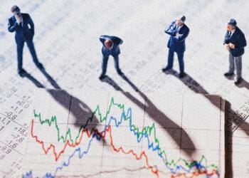 Businessman figurines looking at graph