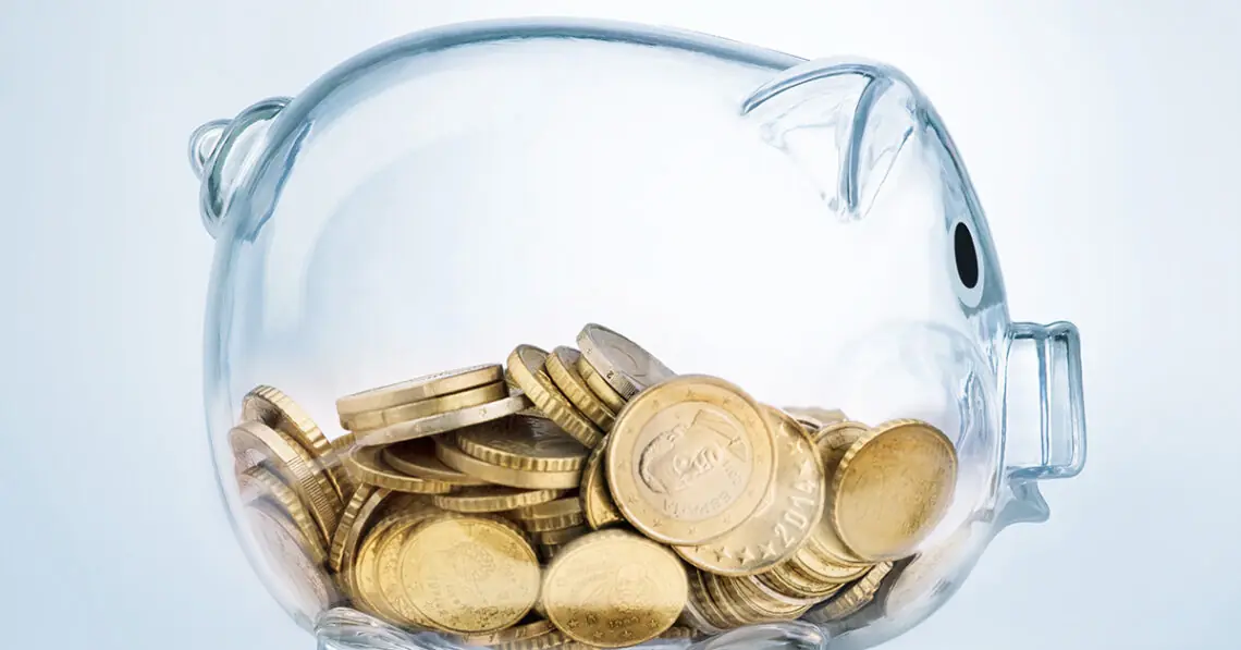a clear piggybank holding coins