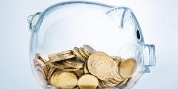 a clear piggybank holding coins