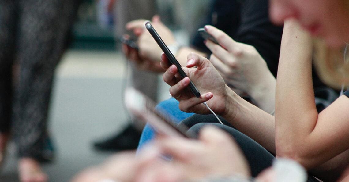 people on train looking at phones