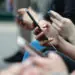 people on train looking at phones