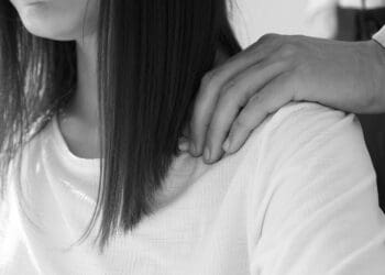 A man puts his hands on a woman's shoulders