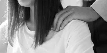 A man puts his hands on a woman's shoulders
