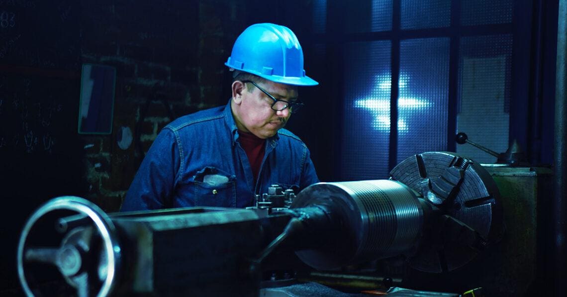 worker in hard hat examining product