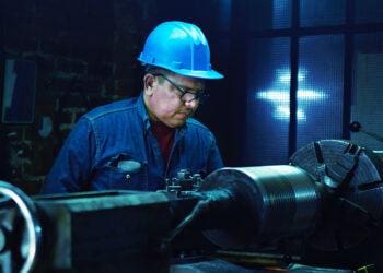 worker in hard hat examining product