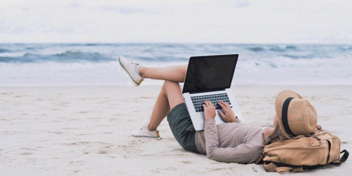 freelance worker sitting on beach