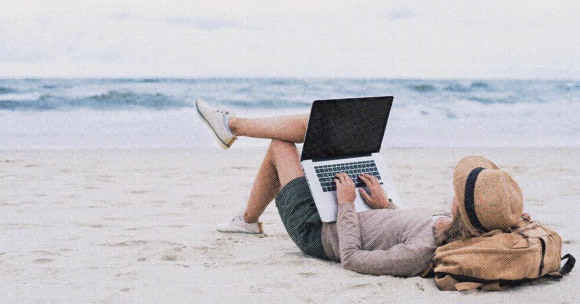 freelance worker sitting on beach