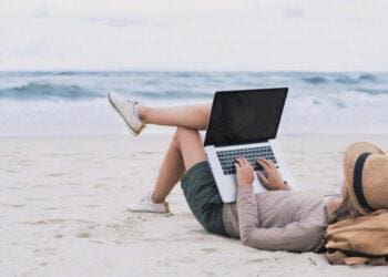 freelance worker sitting on beach